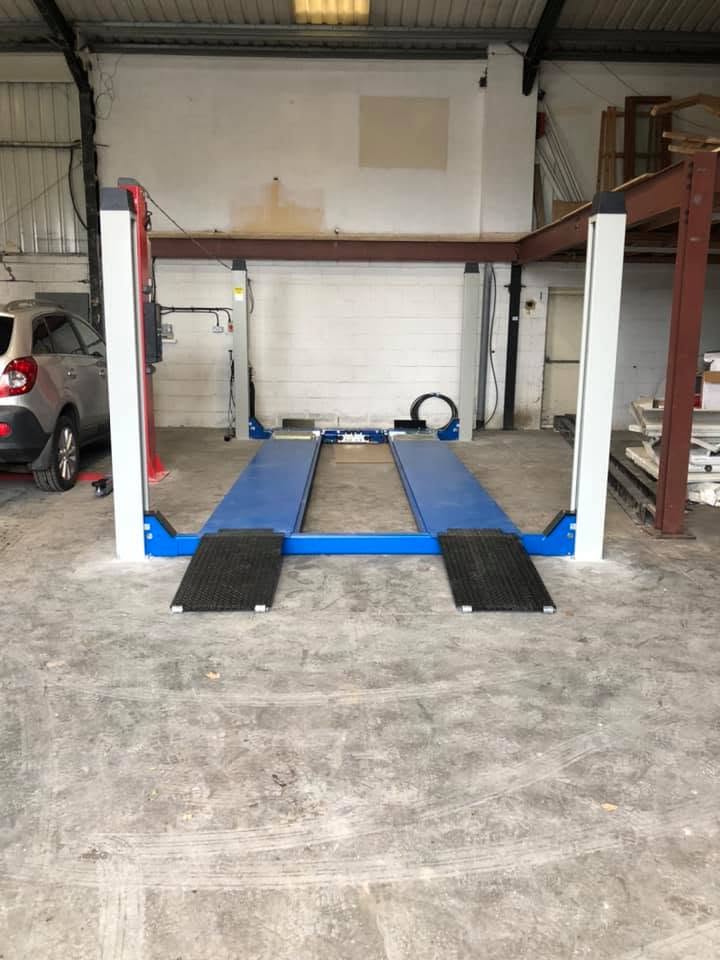The empty workshop bay with the blue four-post lift